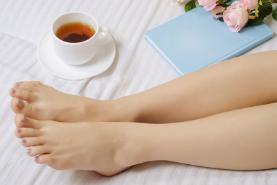 女脚在床上书，茶，花