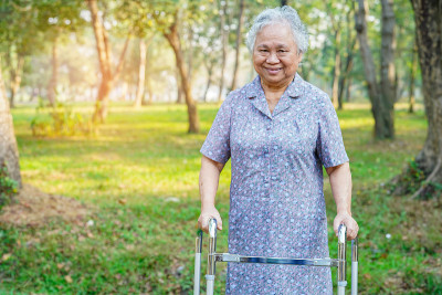 亚洲老年妇女或老年妇女患者与walker在公园散步:健康强的医疗理念