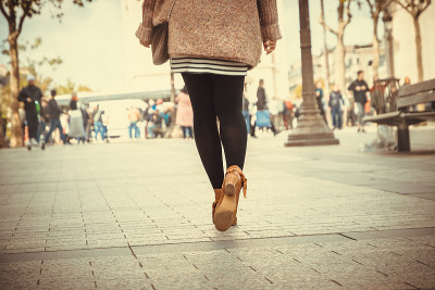 女人穿着棕色的鞋子走在街上。