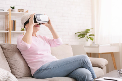 惊奇的资深女士在家里享受VR头盔增强现实