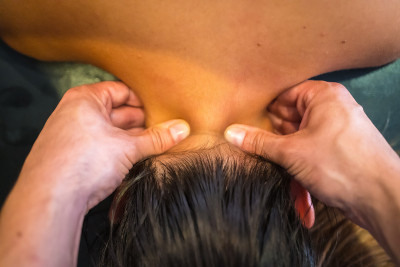 一位年轻的女士正在接受理疗师的双指颈部按摩。理疗,整骨疗法
