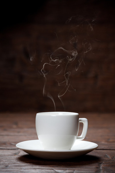 咖啡杯和茶碟放在旧木桌上。