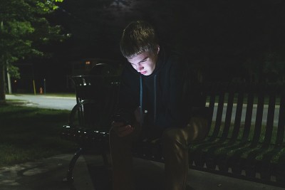 一个青少年在晚上打手机。