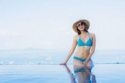 肖像美丽的年轻亚洲妇女快乐的微笑放松户外游泳池度假村