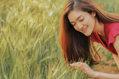 亚洲旅行者穿着衣服愉快地走在小麦农场，自由的生活方式度假