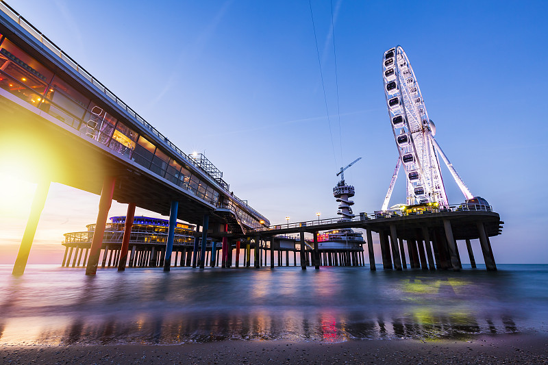 在海岸线、海滩、码头和摩天轮上，彩色的蓝色小时日落，Scheveningen，海牙。