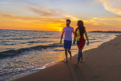 在美丽的夏日，在美丽的海滩上快乐的年轻浪漫的夫妇相爱