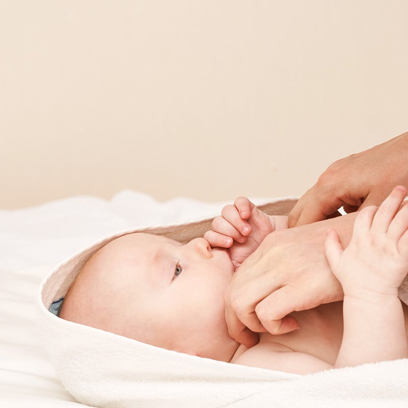 Cute small boy lying at bed. Childhood bath concep