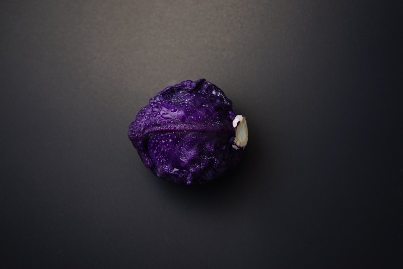 美丽的红色卷心菜，暗红色，紫色叶蔬菜平躺在深色垃圾纹理抽象的背景上。食物，食物色情，暗色摄影的静物。