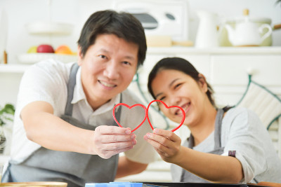 亚洲夫妇拿着红心。