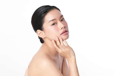 美丽年轻的亚洲女性干净清新的皮肤在白色背景，面部护理，面部护理，美容，美容和水疗，亚洲女性肖像。