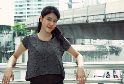 美丽的运动女孩微笑和放松在步行街道在城市。