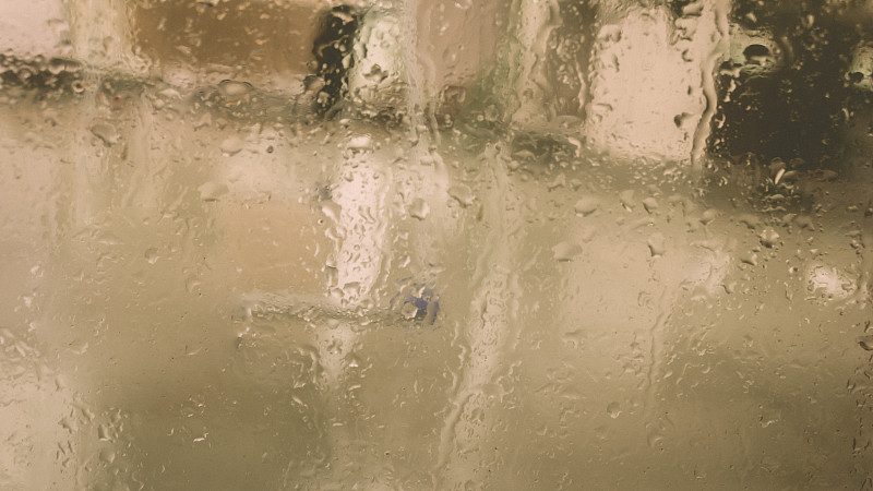 雨点落在湿窗玻璃上。