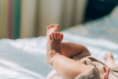 儿童领养与体外受精(IVF)。一个亚洲小孩躺在床上。照顾新生儿