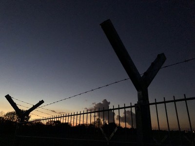 夕阳下有铁丝网的安全围栏