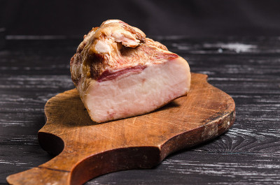一块熏肉放在木砧板上。传统的乌克兰美食。