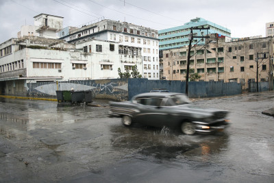 城市场景与经典汽车在雨中溅水