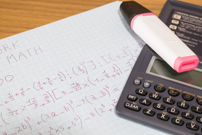 上学时，数学作业用计算器放在木桌上作文