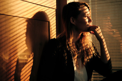 女商人站在有百叶窗的窗户旁