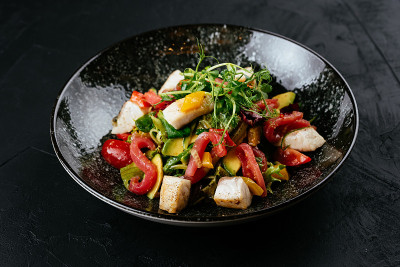 黑色背景上的虾仁、蔬菜和蟹肉沙拉