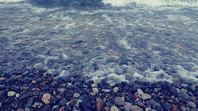 纳乌尔瓦皮湖岸，卵石滩，湖水，浪花，撞击岩石，天空多云
