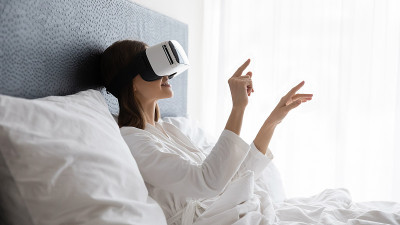 惊奇的年轻女子尝试VR眼镜在卧室