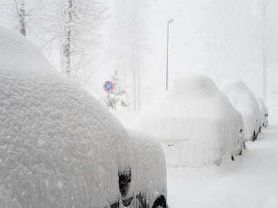 在一个雾天下雪的时候，被大雪覆盖的汽车停在外面