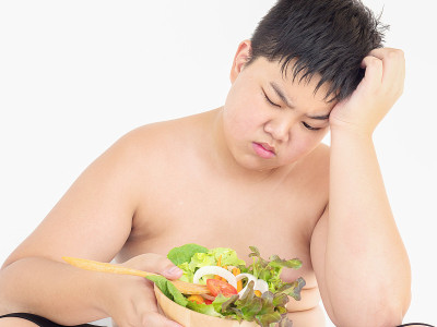 胖男孩讨厌吃蔬菜沙拉