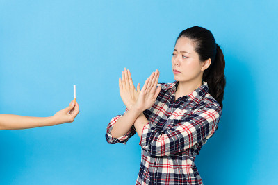 年轻美丽的少女面对香烟
