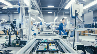 图为电子厂工人在装配线上手工组装电路板。高科技工厂设施。