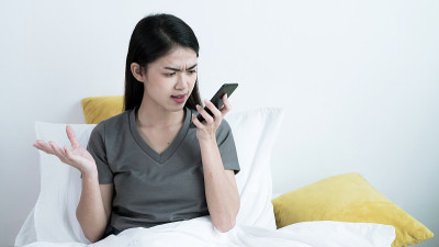 一名亚洲女性和她的朋友或男友打电话，她压力很大，和她说话的人发生了争吵。