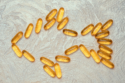 水泥背景上鱼形的Omega3胶囊轮廓。EPA和DHA是人体日常必需的脂肪物质。