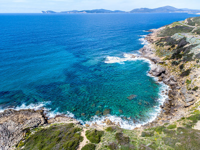 蓝色的海在阿尔盖罗海岸线与卡波卡西亚的背景