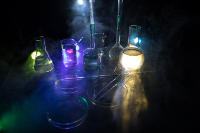 在实验室用溶液测试玻璃烧瓶。科学和医学背景。实验室暗色背景上的试管，科研设备概念