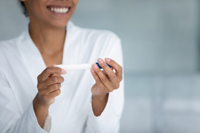 近距离微笑的非洲裔美国妇女持有怀孕测试