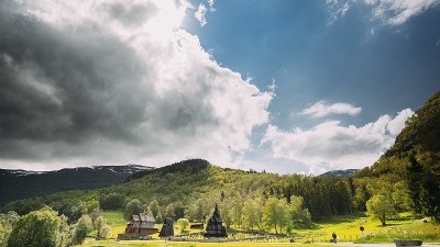 Borgund,挪威。著名的地标斯塔夫柯克一座古老的木制三柱中殿教堂。灿烂的夏日阳光照耀着古老古老的