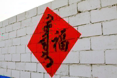 白色墙壁上的汉字和满语，特写照片