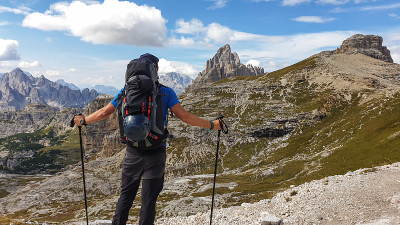Oberbachernspitze——一个背着大背包的男人张开双臂，做着自由的姿势
