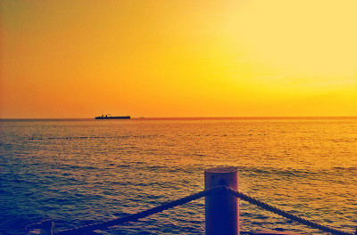 大海，橙色的夕阳和小船