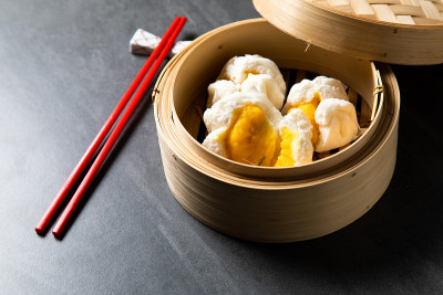 中国传统美食的概念。饺子点心在竹蒸笼内用文字抄写空间。亚洲食物背景