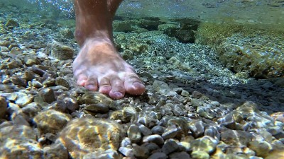 人脚行走在岩石地中海海岸水下