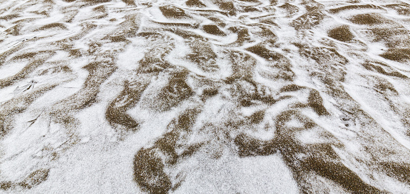 美丽的沙丘覆盖着霜和新雪，在一个荒凉的河岸上，在冬天