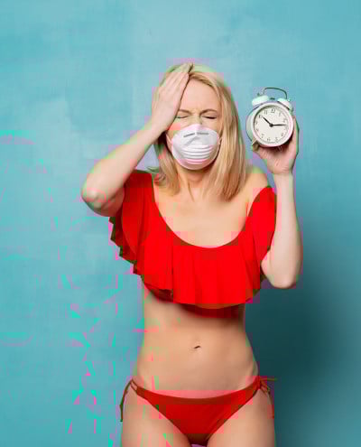 金发女郎穿着比基尼，戴着闹钟面具