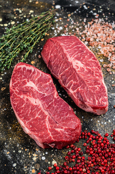 刀锋切，牛肉排。棕色的背景。俯视图
