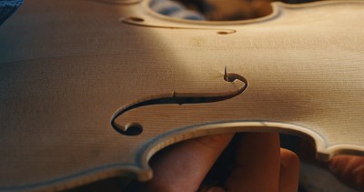 近距离观察专业的工匠制琴师在一个作坊里制作手工小提琴。