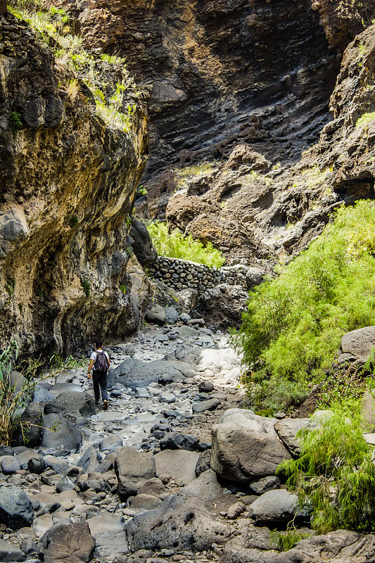 特内里费岛马斯卡峡谷的岩石，显示出凝固的火山熔岩流层和拱形构造。峡谷或峡谷从900米的高度通向海洋