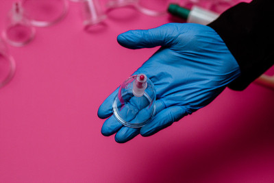 真空泵和罐的hijama。武器。在粉红色的背景上