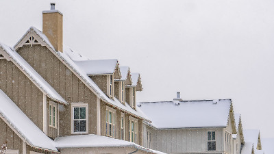 在冬季，沿着房屋的雪地上留下的全景小径