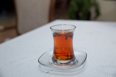 阿塞拜疆传统armudu茶梨形玻璃杯。阿塞拜疆红茶与复古的白色桌子。土耳其黑茶梨形杯，阿塞拜疆传统芳