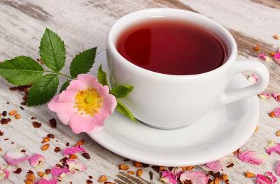 一杯以野生玫瑰为背景的茶